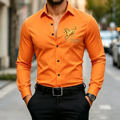 A man wearing a bright orange long-sleeve button-up shirt with a gold horse graphic and the text 'Success at first try' on the left chest, 