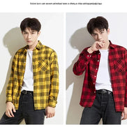 Two male models wearing long-sleeve plaid button-up shirts over white t-shirts and dark jeans, shown side by side against a plain light background. 