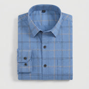 A folded light blue long-sleeve plaid dress shirt with a pointed collar and dark buttons, shown on a clean white background.