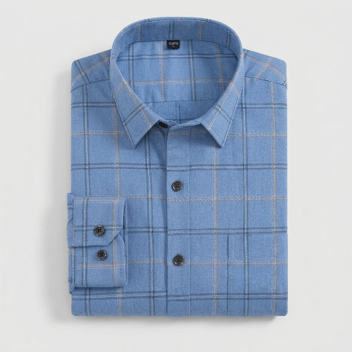 A folded light blue long-sleeve plaid dress shirt with a pointed collar and dark buttons, shown on a clean white background.
