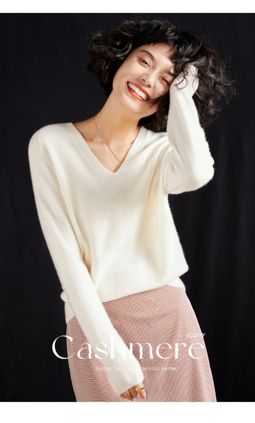 Woman wearing a white cashmere sweater with a black background