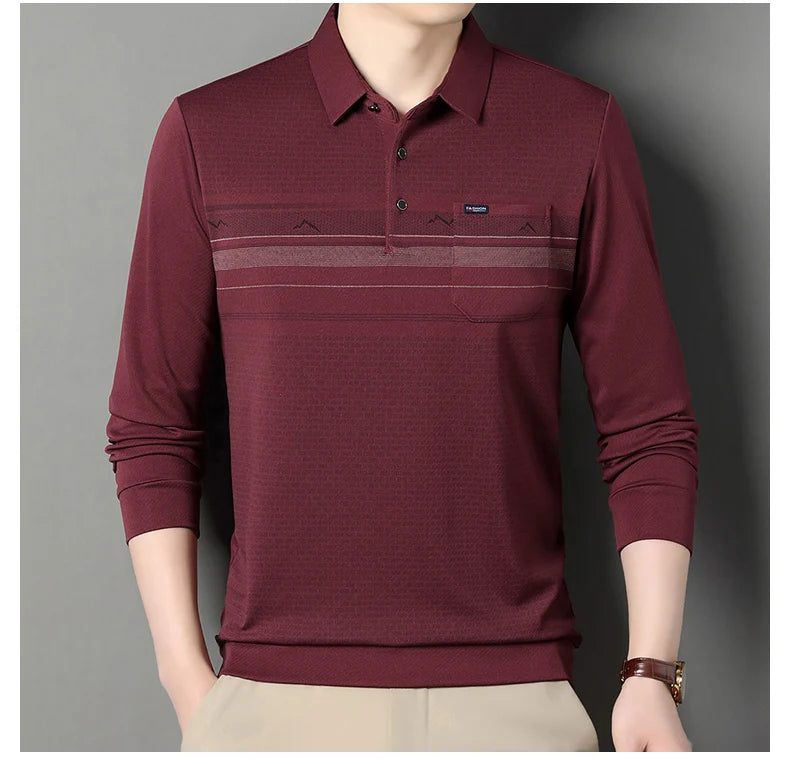A man wearing a long-sleeve polo shirt in burgundy with horizontal textured stripes across the chest, paired with beige pants, shown against a plain gray background.