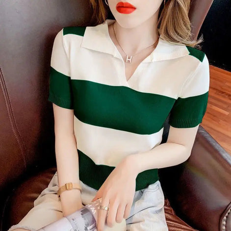 A woman wearing a short-sleeve knit polo shirt with horizontal dark green and off-white stripes, seated on a brown leather chair.