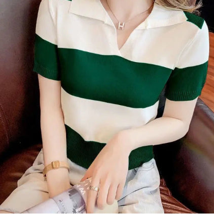 A woman wearing a short-sleeve knit polo shirt with horizontal dark green and off-white stripes, seated on a brown leather chair.