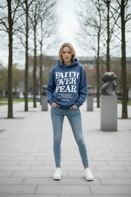 Blue hoodie with 'Faith Over Fear' text on a wooden surface