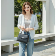 A person wearing a soft white fuzzy V-neck cardigan over a light gray top, paired with light blue jeans, 