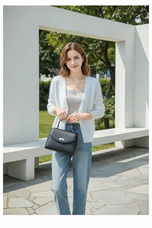 A person wearing a soft white fuzzy V-neck cardigan over a light gray top, paired with light blue jeans, 