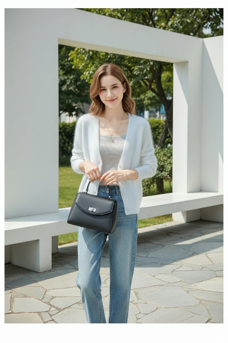A person wearing a soft white fuzzy V-neck cardigan over a light gray top, paired with light blue jeans, 