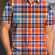 Person wearing a short-sleeve plaid shirt with orange, blue, and white pattern.