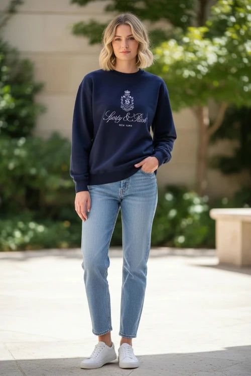 Person wearing a navy blue sweatshirt with a logo and text on a white background