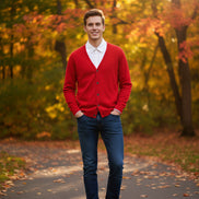 Red cardigan over a white shirt on a wooden hanger against a dark background