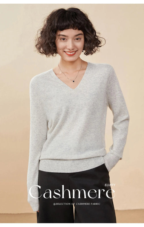 Woman wearing a gray cashmere sweater with a beige background