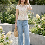 Floral blouse on a hanger against a clothing store background