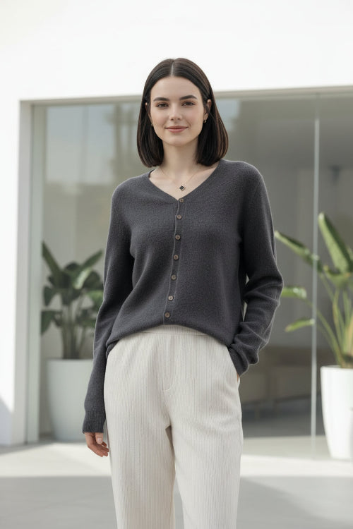 Person wearing a gray cardigan with buttons in a clothing store.