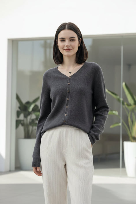 Person wearing a gray cardigan with buttons in a clothing store.