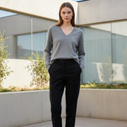 Woman wearing a gray sweater with a plain background