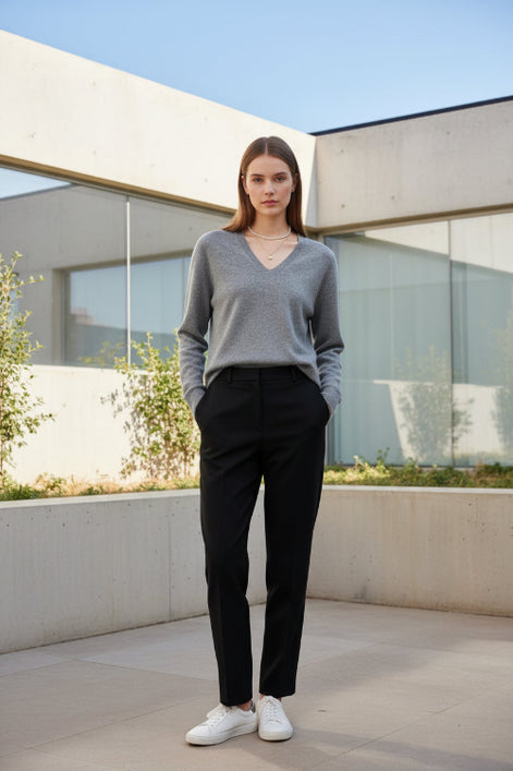 Woman wearing a gray sweater with a plain background