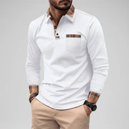 Man wearing a white long-sleeve shirt with plaid accents on a city street.