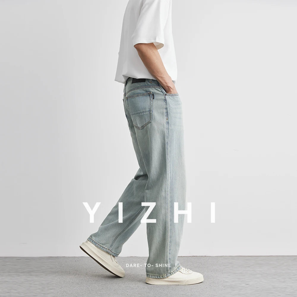 Person wearing light blue jeans and a white shirt with 'YIZHI' branding.