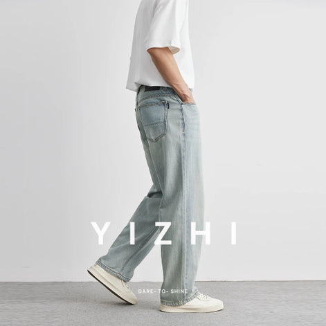 Person wearing light blue jeans and a white shirt with 'YIZHI' branding.