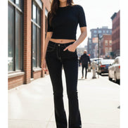 Person wearing black jeans and platform shoes in a room with wooden floor.