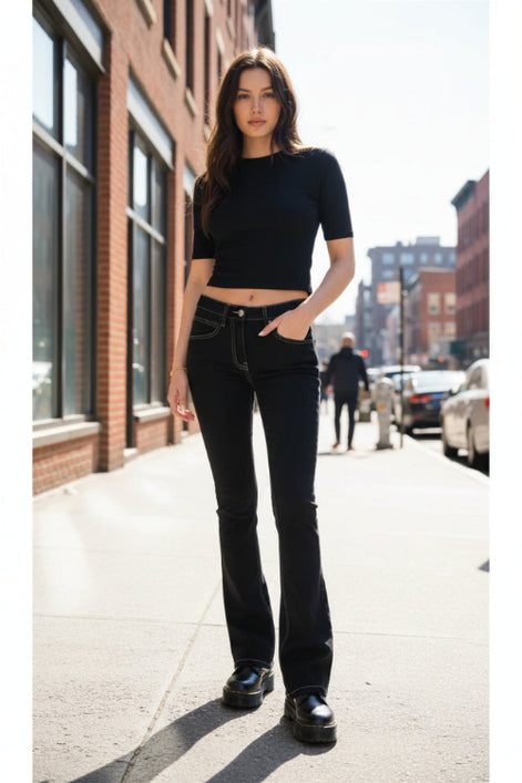 Person wearing black jeans and platform shoes in a room with wooden floor.