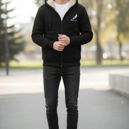 Black hoodie with beige lining on a textured beige background