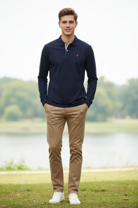 Navy long-sleeve polo shirt with a small red logo on a rack with other colored shirts.