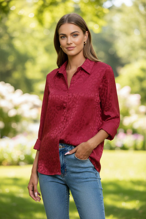 Red leopard print shirt worn by a person against a gray background