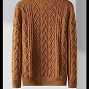 Brown sweater with intricate pattern on a hanger against a gray background