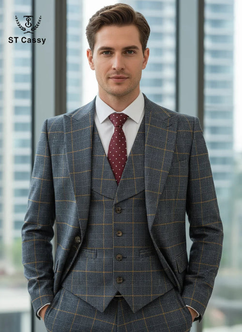 Man wearing a gray checkered suit with a red patterned tie in front of a blurred cityscape.