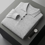 Folded gray polo shirt with a watch on a dark surface