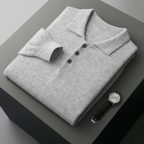 Folded gray polo shirt with a watch on a dark surface