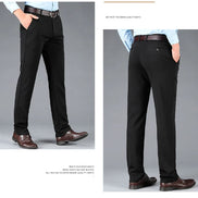 Black dress pants worn by a person on a gray background