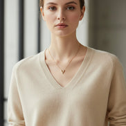 Woman wearing a beige sweater against a black background