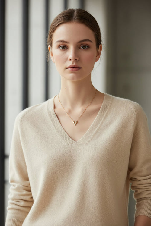 Woman wearing a beige sweater against a black background
