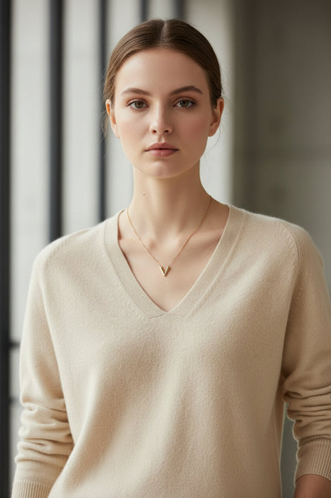 Woman wearing a beige sweater against a black background
