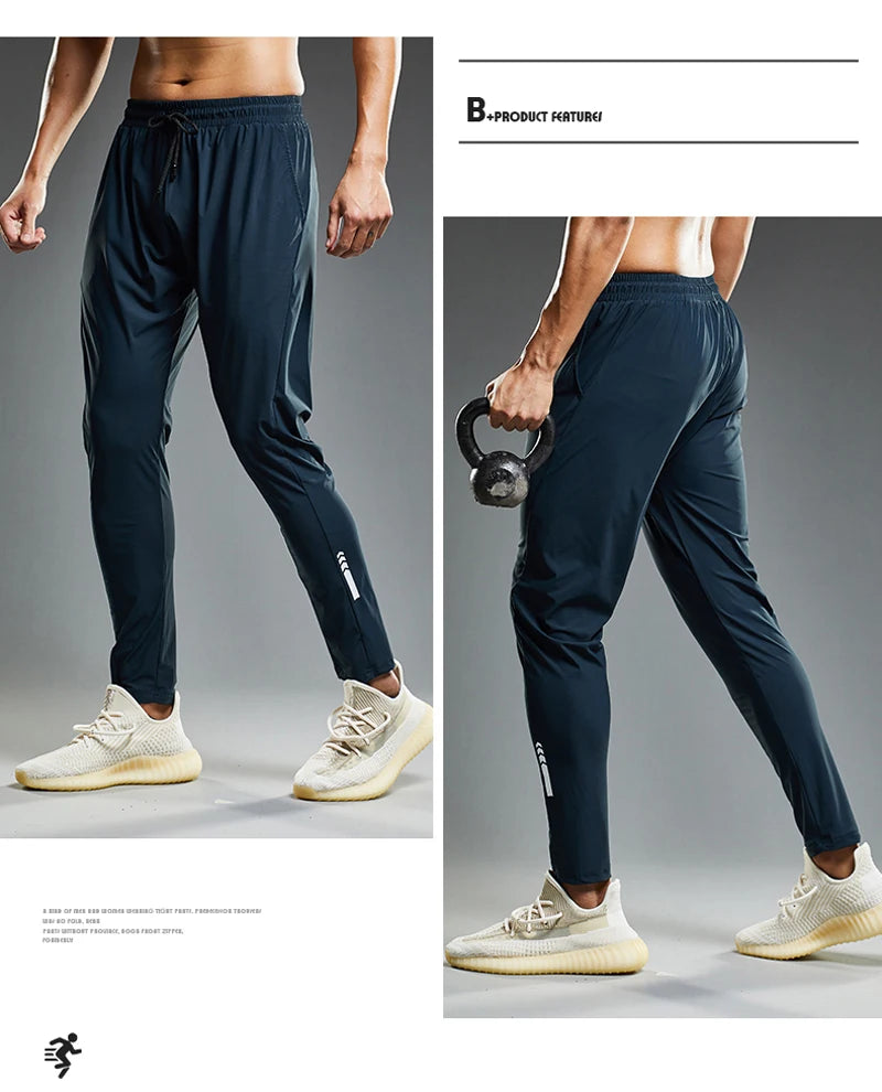 Navy blue athletic pants worn by a person on a gray background