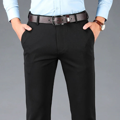 Person wearing black pants with a brown belt on a gray background