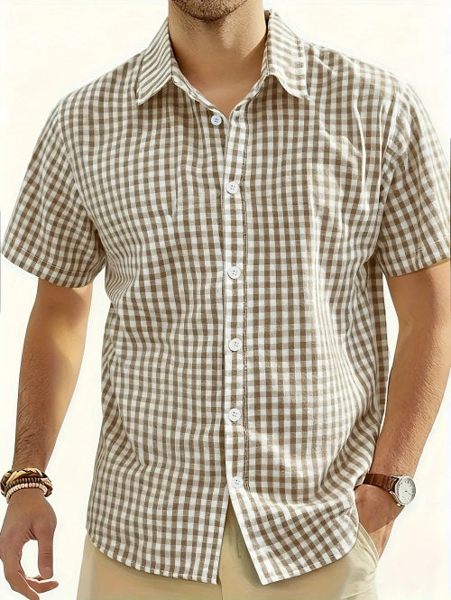 Man wearing a brown and white checkered shirt with a neutral background