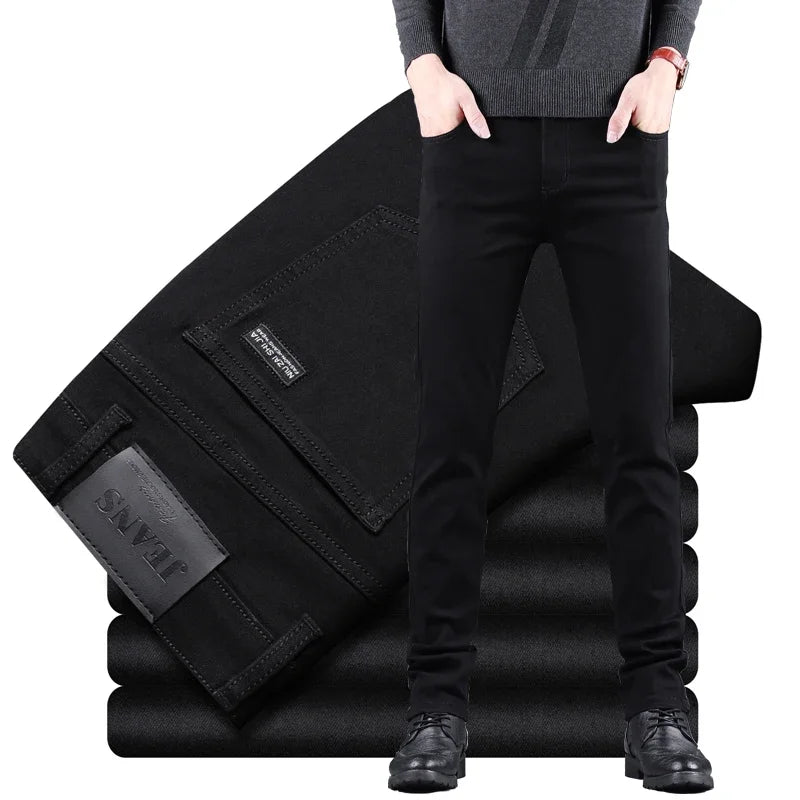 Person wearing black pants standing next to a stack of folded black pants with 'SNY' branding.
