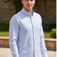 Folded blue and white striped shirt with brand label on a white background