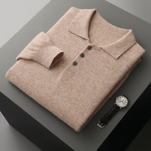 Folded beige polo shirt with a watch on a gray surface