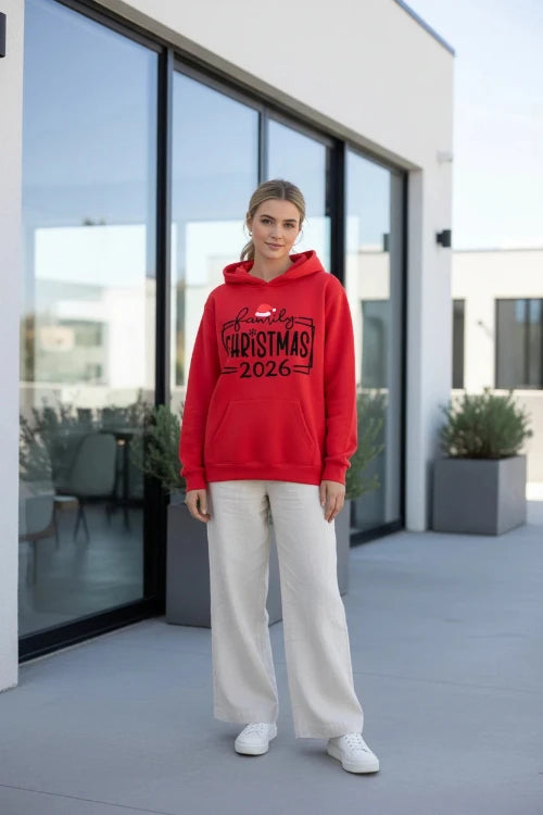 A bright red pullover hoodie laid flat on a dark textured surface, featuring a black 'family CHRISTMAS 2026'