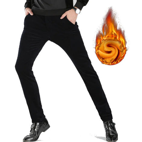 A person wearing slim black pants with hands in pockets, shown from the waist down on a white background. A flame-shaped graphic over the thigh suggests warm lining.