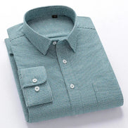 A folded long-sleeve button-down dress shirt with a fine green and white micro-check pattern, featuring a pointed collar,