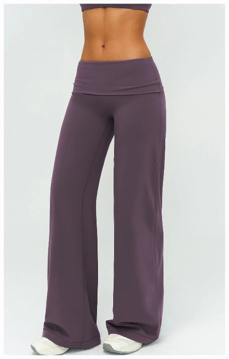 Purple yoga pants worn by a person on a white background
