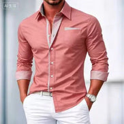 Man wearing a pink dress shirt with rolled-up sleeves and white pants against a blurred background