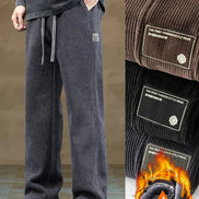 Gray sweatpants with a flame graphic and brand logo on a neutral background