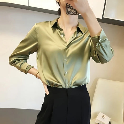 Sage green satin blouse worn by a model taking a mirror selfie.